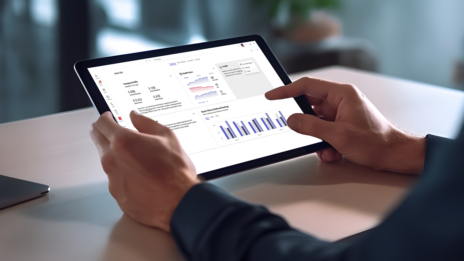A person's hands are shown holding a tablet with data visualizations displayed.